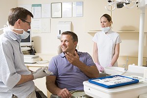 Man in dental chair talking to dentist