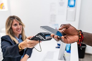 Smiling receptionist taking payment from patient