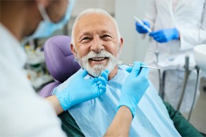 a patient smiling after receiving his new dentures