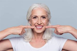 Senior woman pointing to smile