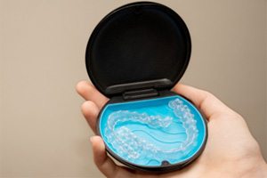 Patient holding Invisalign aligners in storage case