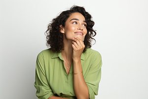 Woman in green blouse wearing curious expression