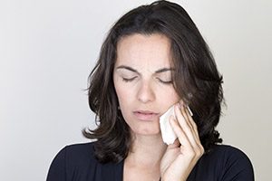 Woman holding jaw in pain