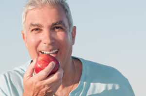 man smiling preparing to eat apple