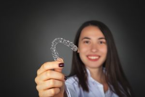 woman holding clear aligner