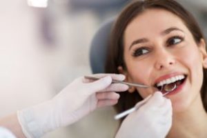 Woman with brown hair getting an exam from a dentist 