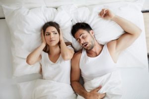 woman annoyed at her partner’s chronic snoring from sleep apnea 