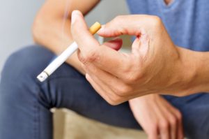 Man’s hand holding cigarette 