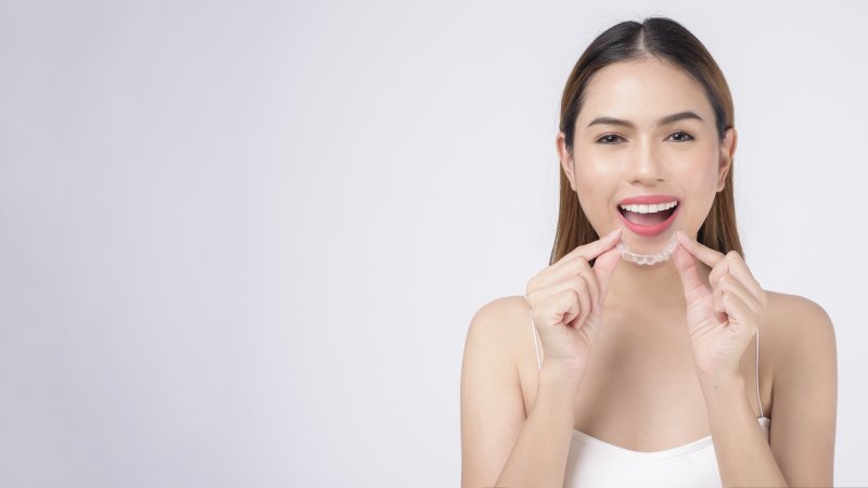 a patient holding an Invisalign tray